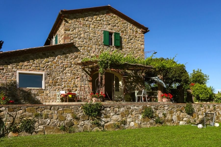 une ferme toscane typique, un bâtiment en pierre couvert de fleurs